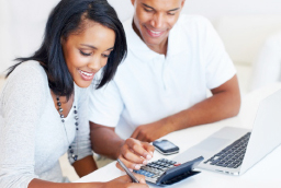 Couple looking at laptop and calculator